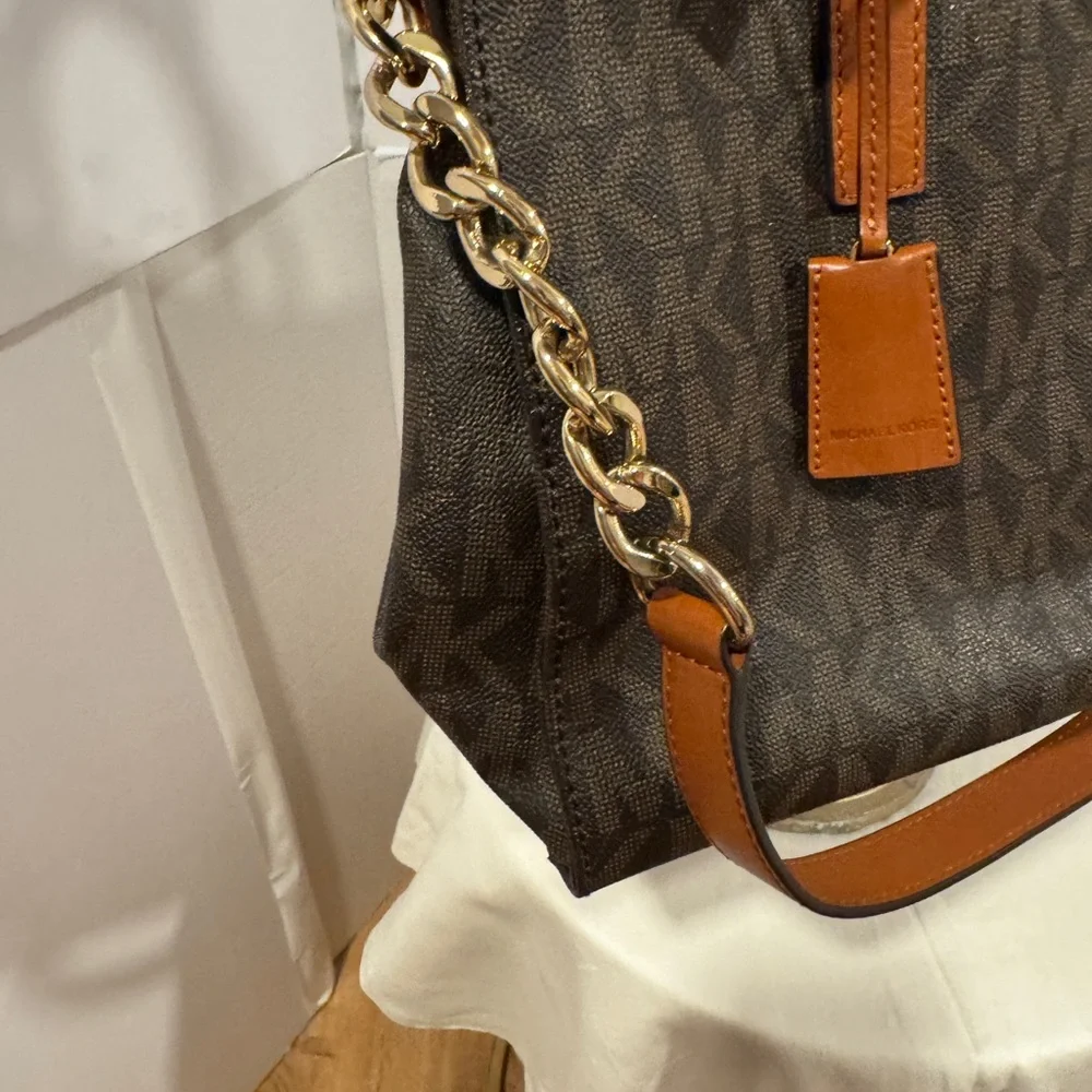 Michael Kors Emblemed satchel style purse. Strap has some gold chain and leather